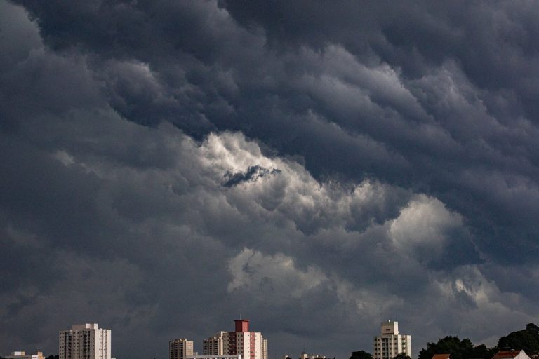 Edifícios de Curitiba sob um céu escuro com nuvens carregadas que anunciam a aproximação de uma tempestade